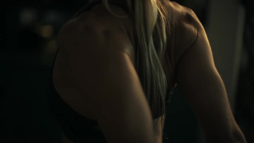 Close up of a womans back as she stretches her arms behind her