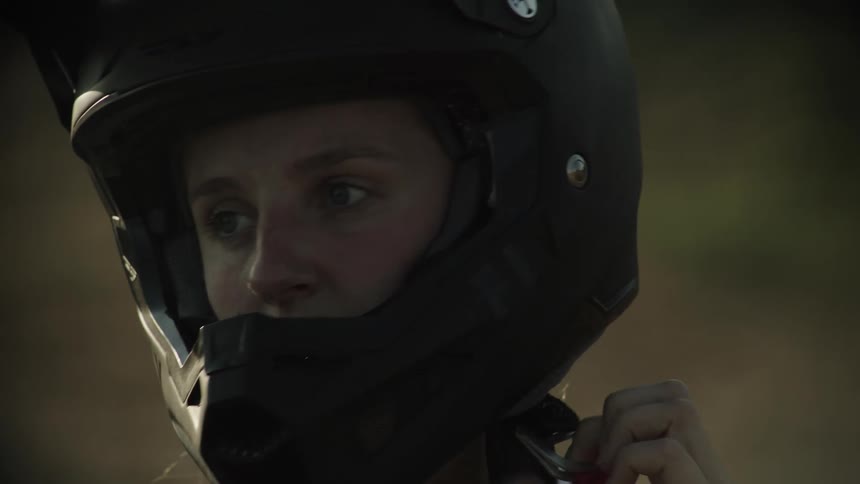 White woman putting on a motorcycle helmet