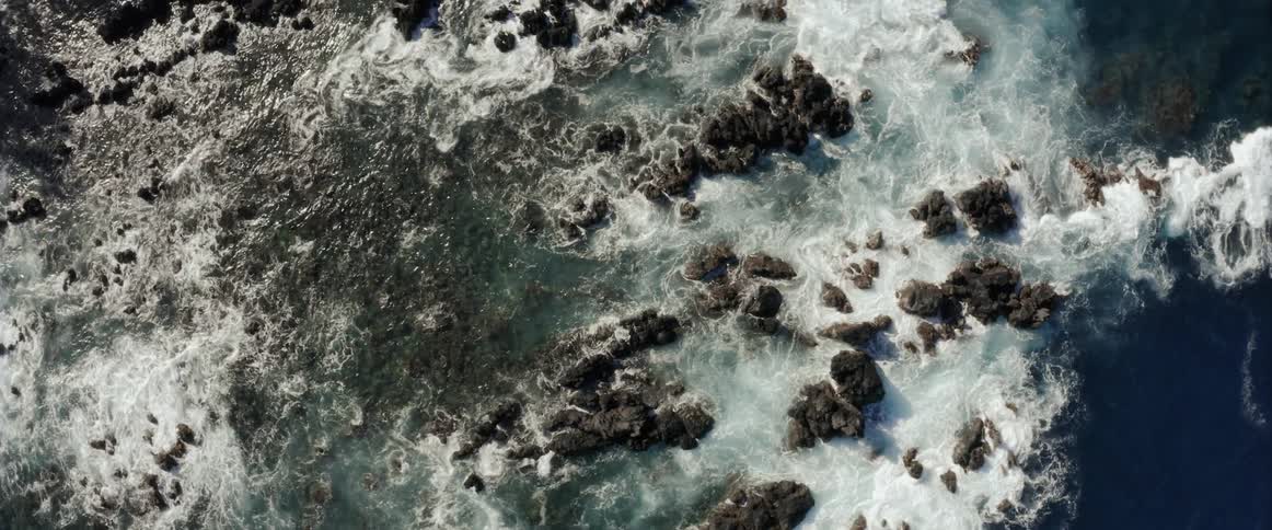 Waves are crashing violently against a rocky shoreline
