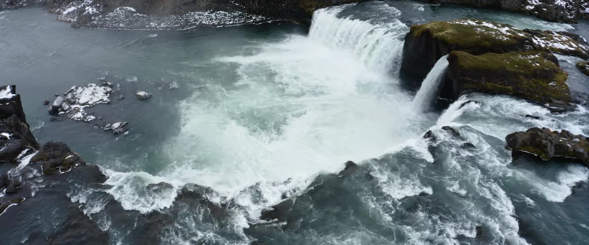 An aerial view of a large waterfall in winter