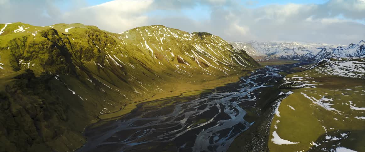An aerial view of snowy mountains and rivers in winter
