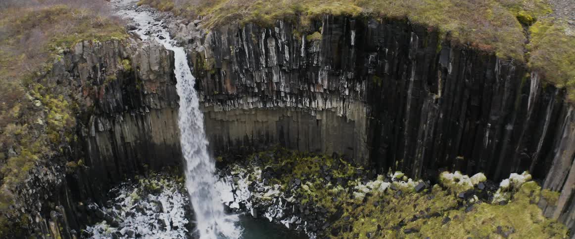 A waterfall flowing over a cliff in nature in winter
