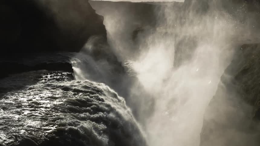 A slow motion shot of water rushing over a waterfall