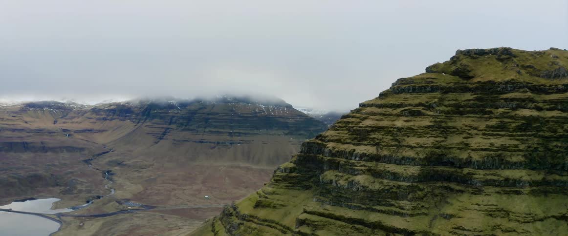 An aerial view of a mountain in nature on a cloudy winter day