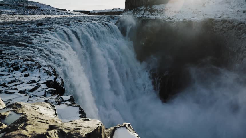 Aerial view of a wide waterfall streaming down the rocky slopes of a mountain
