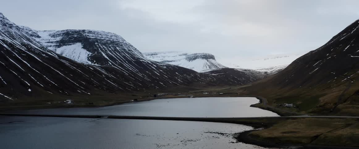 Camera very slowly pans past mountains and a lake
