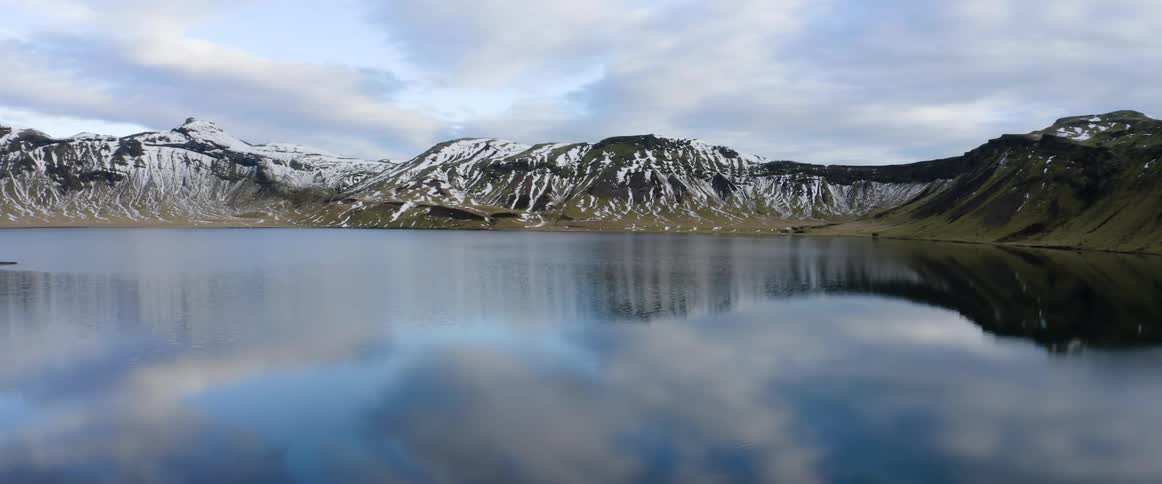 Clouds floating above a snowy mountain lake in winter