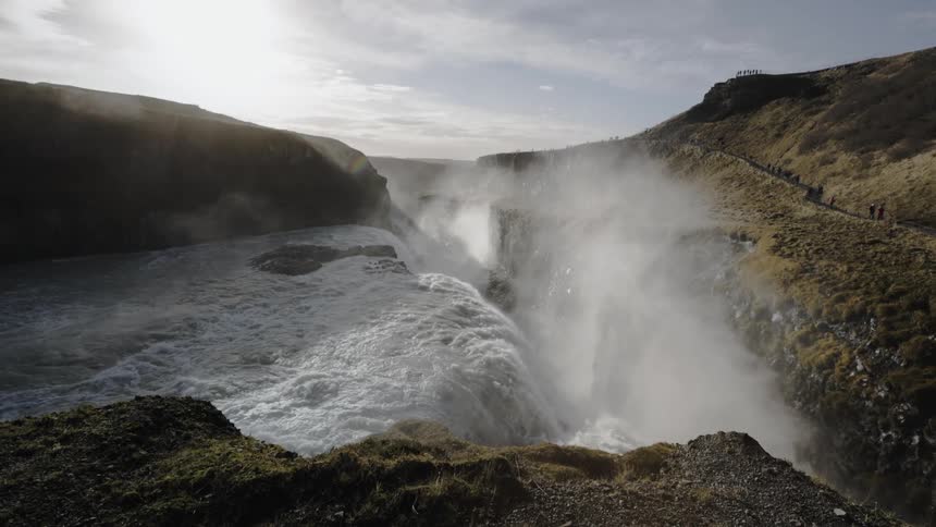 A river flows to the edge of a cliff and becomes a waterfall down into a canyon