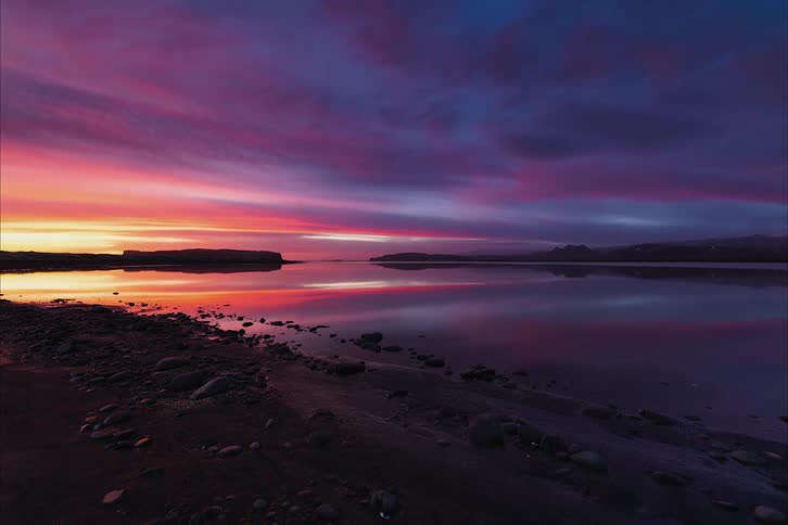 The sun setting over a calm lake in nature