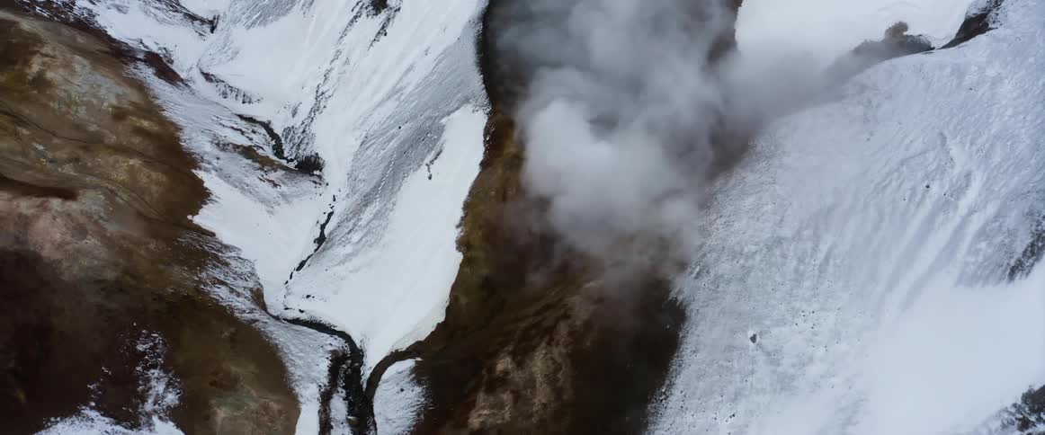 Steam rising from a snowy geyser in nature