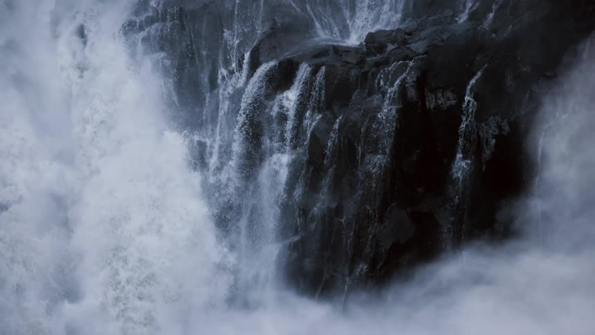 Steam rising around a large waterfall in nature