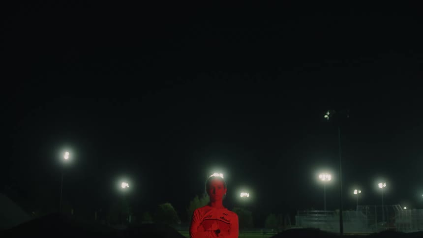 A girl is standing outside at night