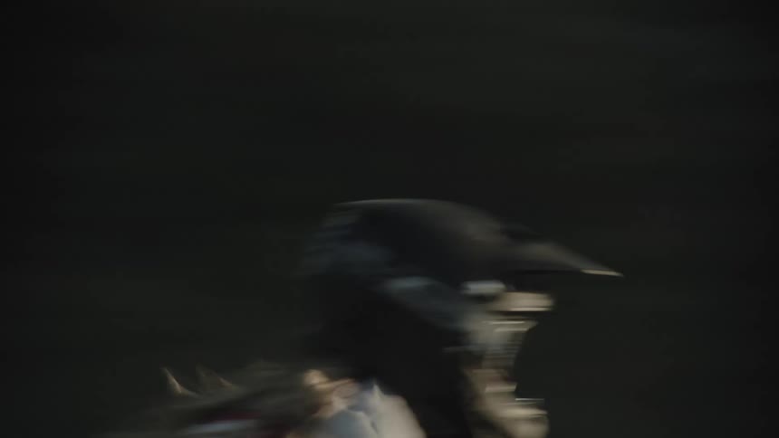 Person rides a bicycle at full speed over the bumps on a gravel track at daytime