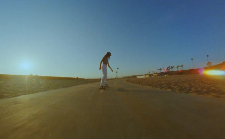 A girl is riding on a longboard