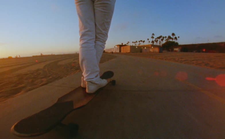 A person is riding their long board near the beach
