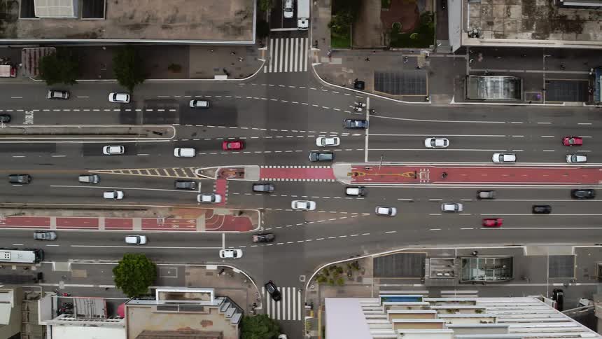 Aerial top down view of cars driving on the light traffic in the city streets