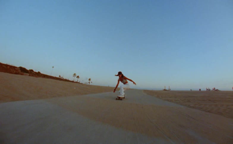 A view of a woman skateboarding outdoors