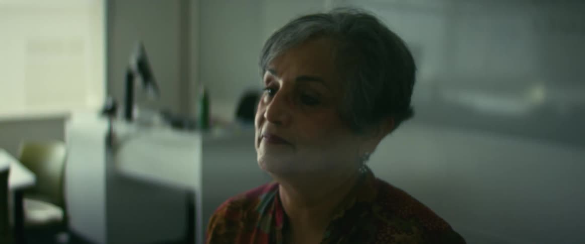 Female teacher holding books and walking to the middle of the classroom