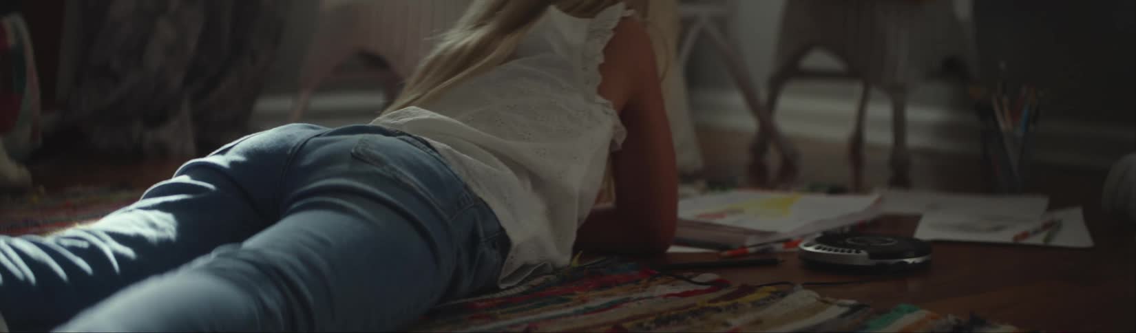 Young girl resting over the carpet on the living room floor reading books