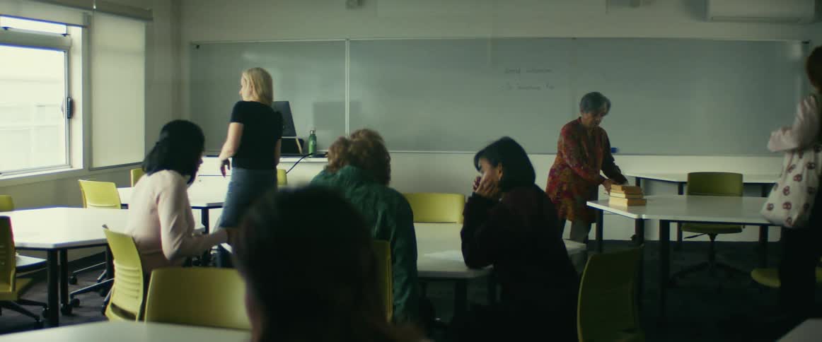 Group of students enter a classroom and find a seat in front of the teacher