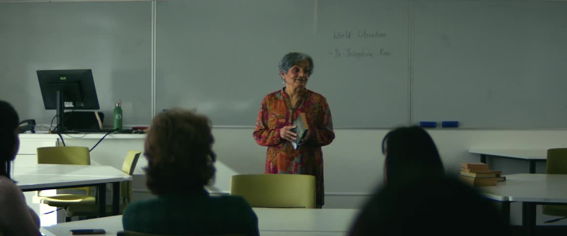 College students sitting at desks listen to professor giving lecture in class