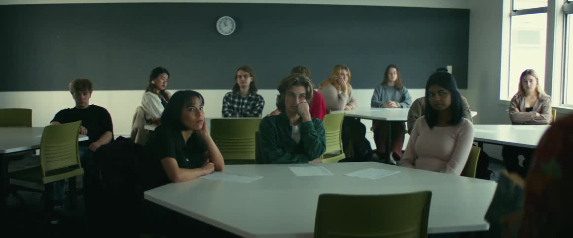 Students listen to lecture from barely shown teacher in foreground