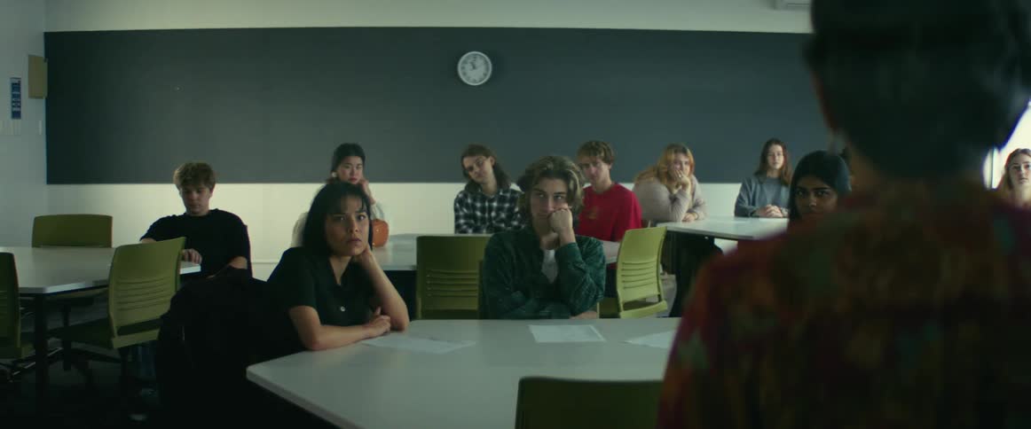 A teacher is speaking to a group of students in a classroom