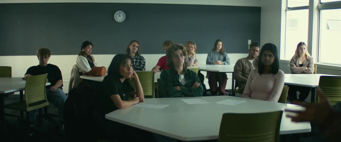 Group of university students sitting in a classroom listening to a teacher