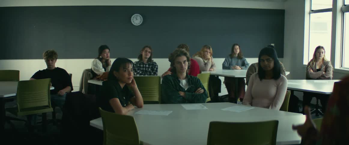 College students sitting at desks listen to professor giving lecture in class