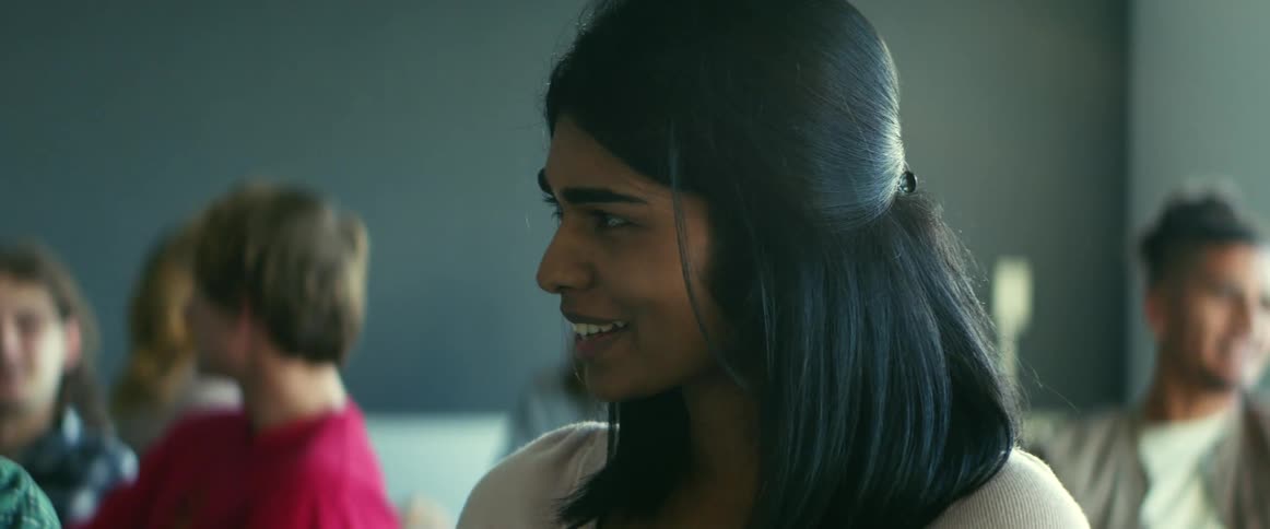 University student sitting on a chair in the classroom talking to a classmate