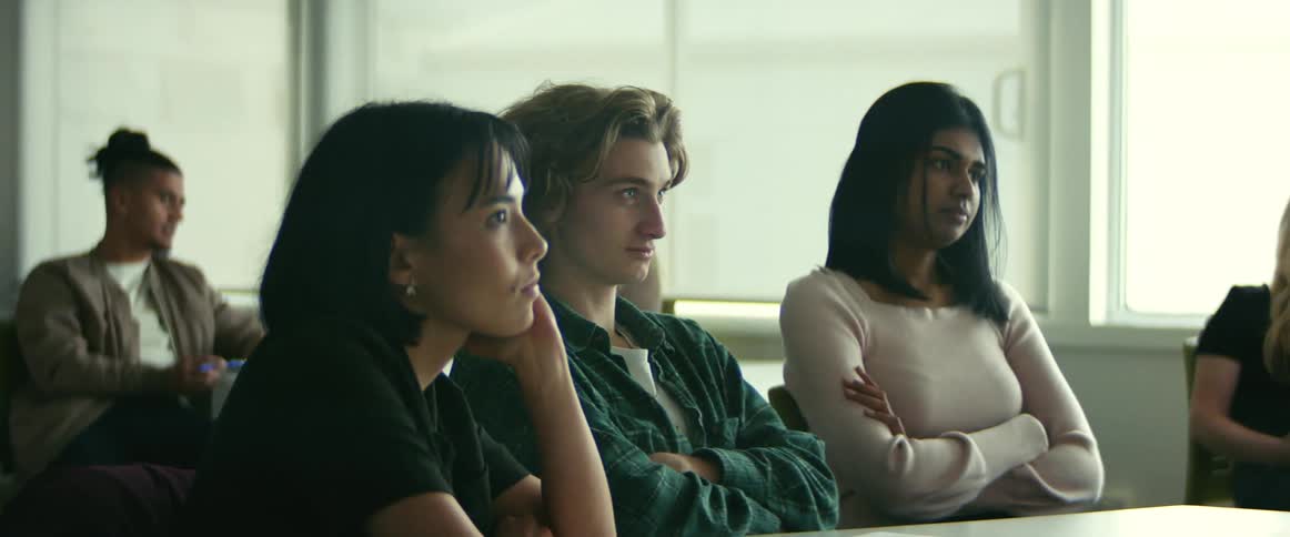 College students sitting at desks listen to professor giving lecture in class