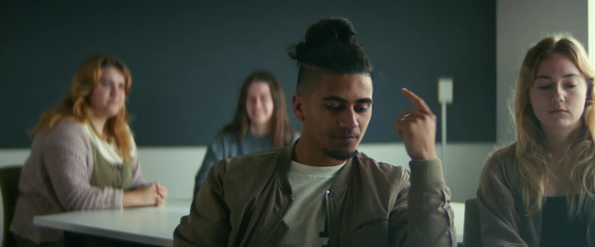 People talk while waiting in room with a chalkboard