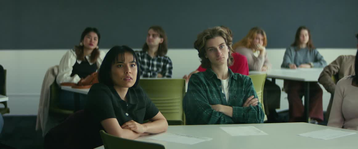 University students sitting on chairs in the classroom listening to the teacher
