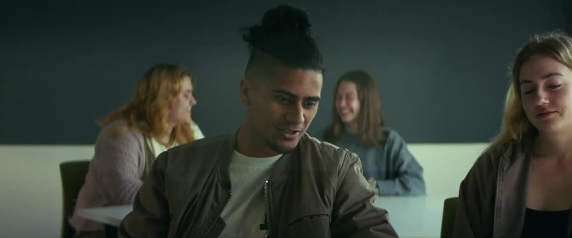A male student talks to his female classmate before class gets started