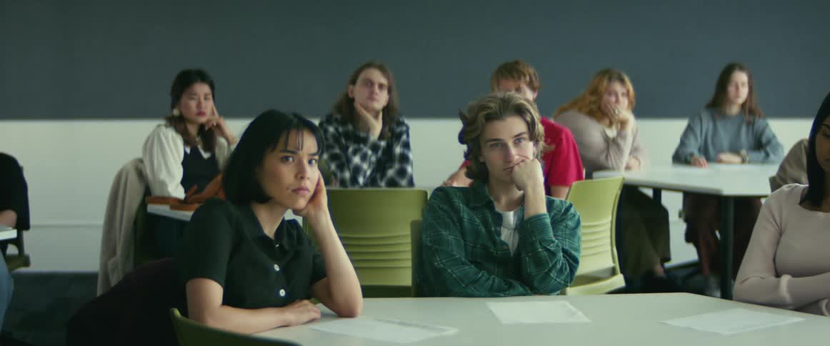 University students sitting on chairs in the classroom listening to the teacher