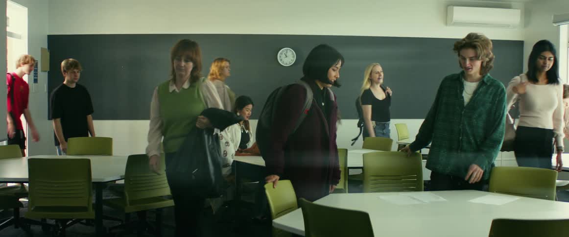 College students enter classroom with professor waiting