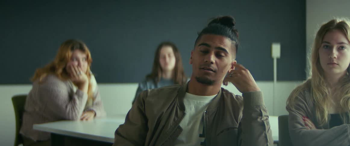 University students sitting on chairs in the classroom listening to the teacher