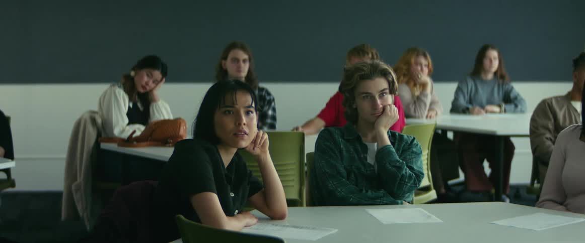 College students sitting at desks listen to professor giving lecture in class