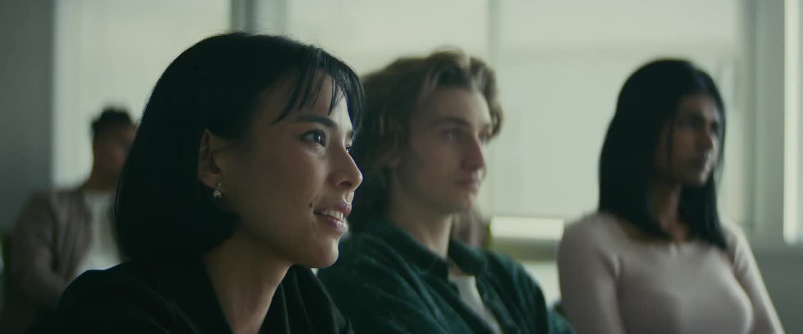 Camera slowly zooms towards a female student as she nods gently in apparent understanding