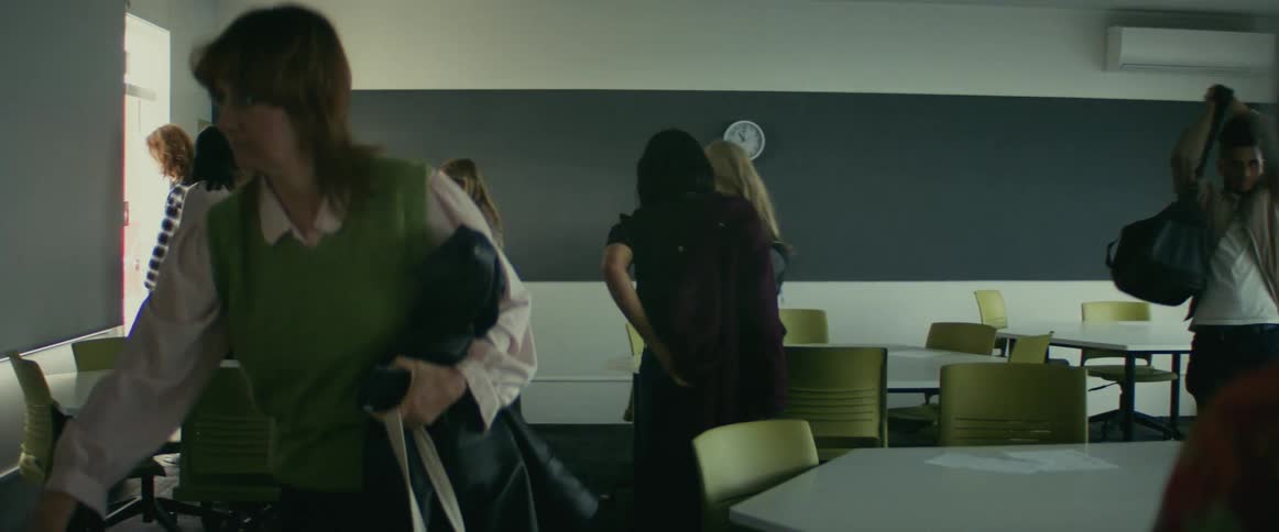 A teacher watches as her students leave her classroom