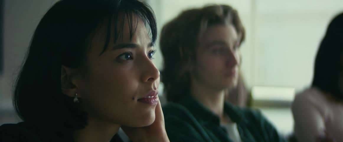 A female student listening to a lecture smiling and looking enthralled