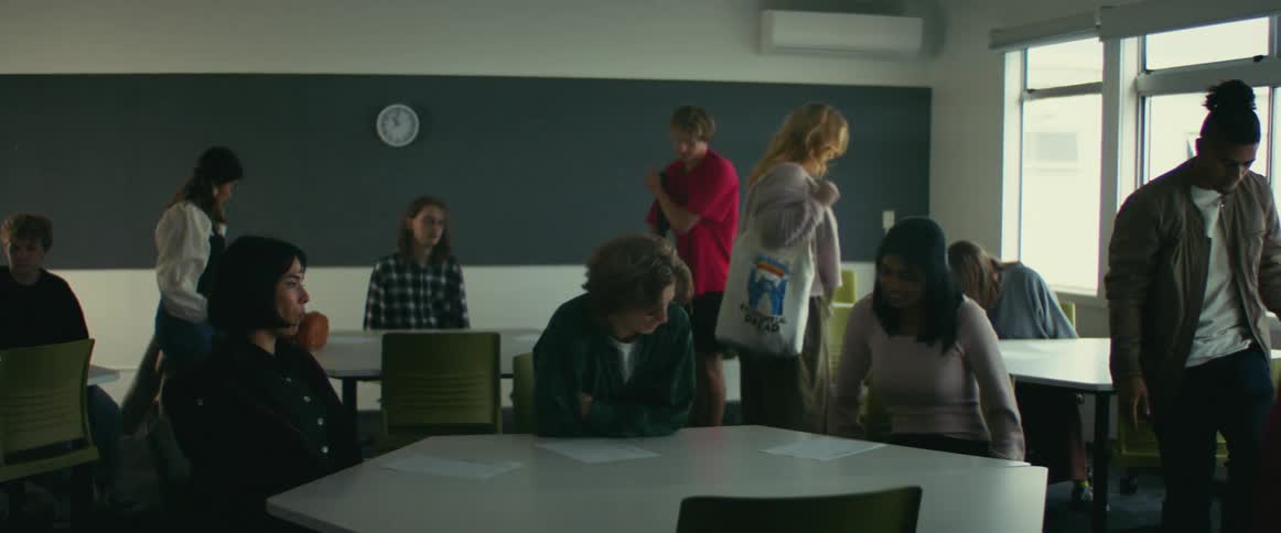 A group of people walks into a classroom and find a seat at a table