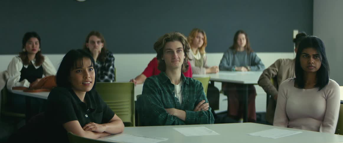College students sitting at desks listen to professor giving lecture in class
