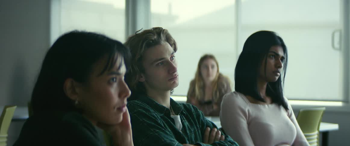 College students sitting at desks listen to professor giving lecture in class