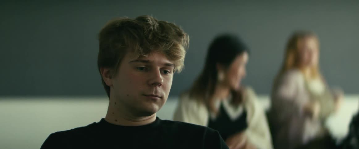 Male student looks off into the distance and then smiles