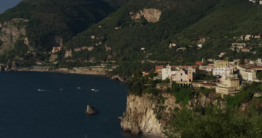 Boats travel past the coastal town