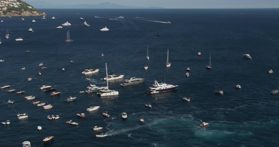 Aerial view of boats anchored in the calm blue ocean waters of a bay
