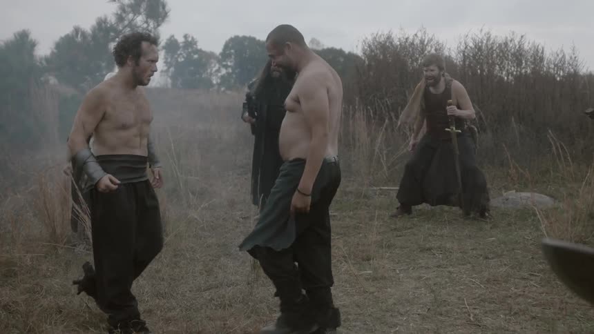 Two men begin fighting as others watch on