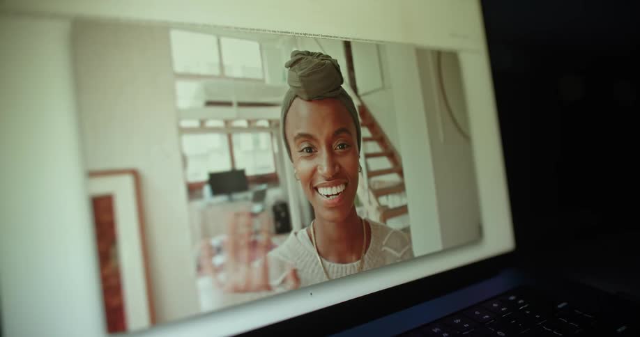 Face of a happy young woman smiling and waving on a video call from a laptop