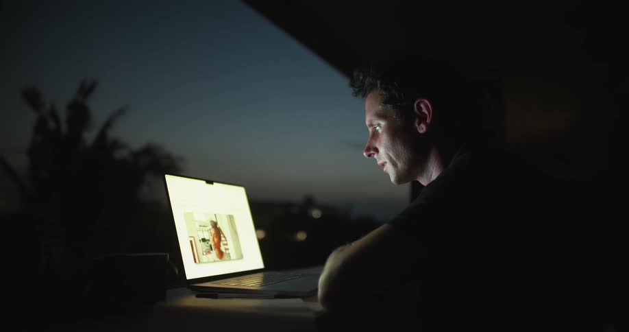 Man engages in a video call with a woman via a laptop